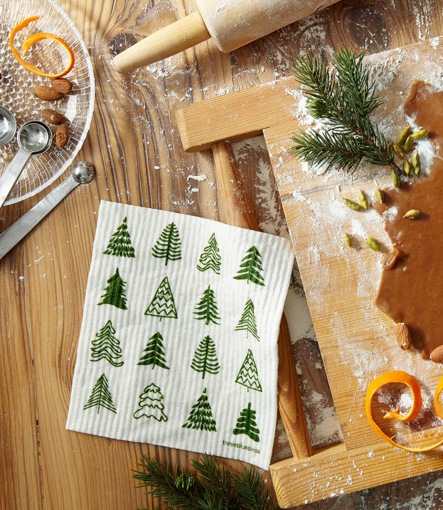 
                  
                    Woodland Trees Swedish Dishcloth by Three Bluebirds on a countertop baking scene.
                  
                